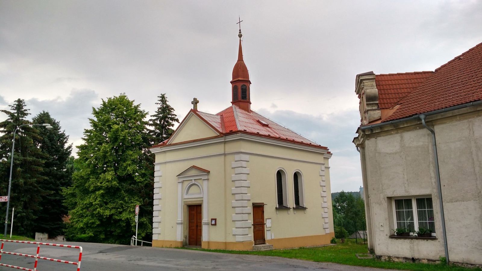 Žlutá kaple Nanebevzetí Panny Marie s bílým štítem a štíhlou vížkou s červenou střechou